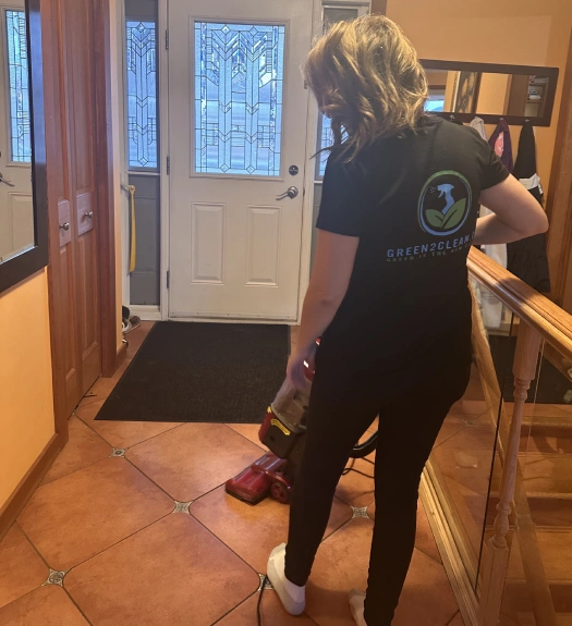 A member of the Green2Clean cleaning company using a vaccuum.