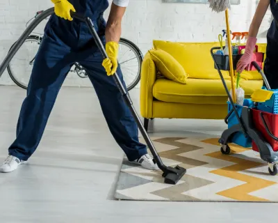 A janitor cleaning a carpet in an office.